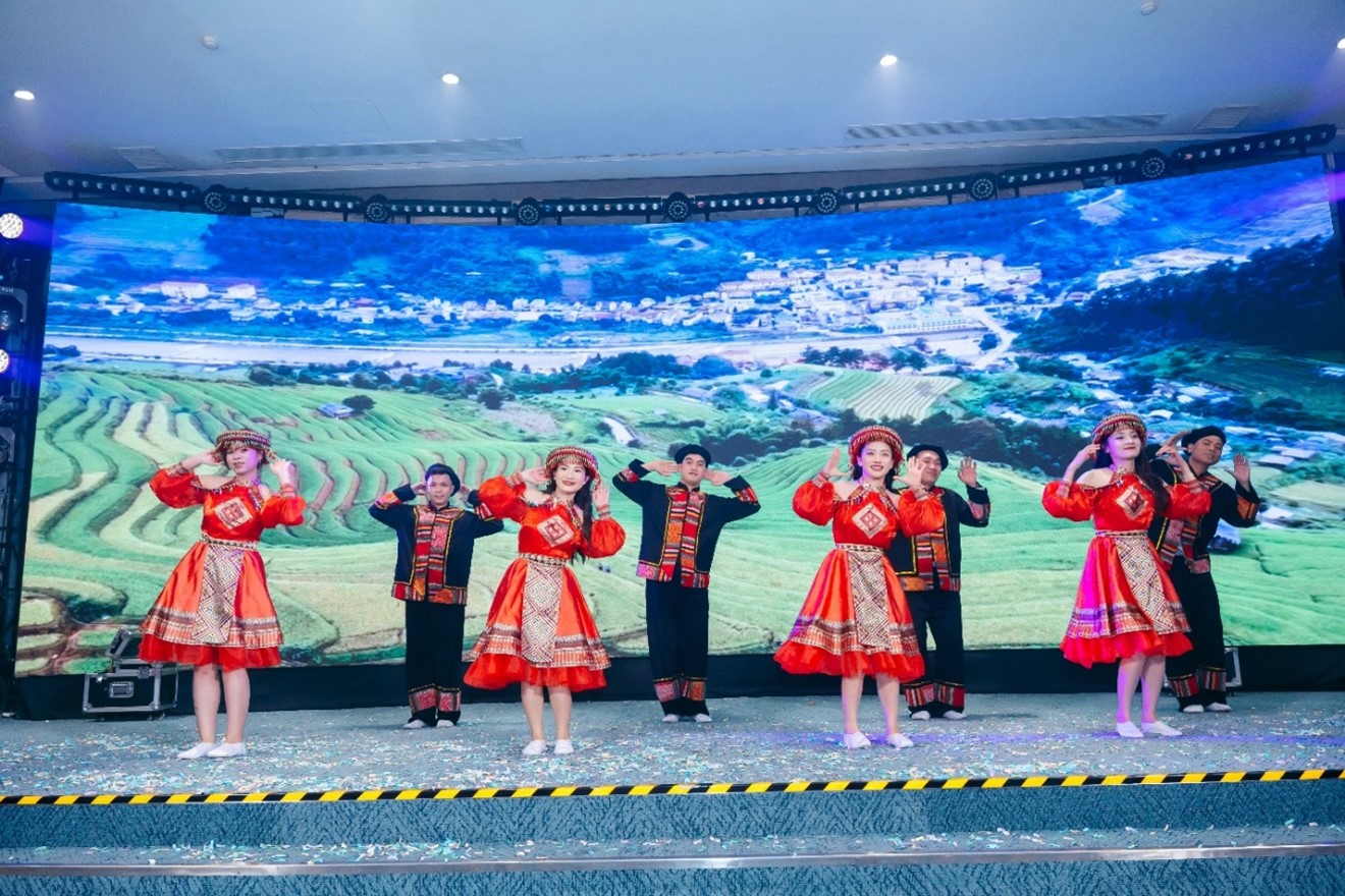 A group of people in red dresses on a stageDescription automatically generated